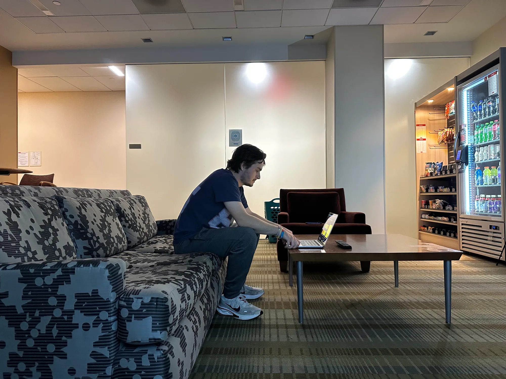 An Elevator Pitch cast member seated by a laptop on the lounge set