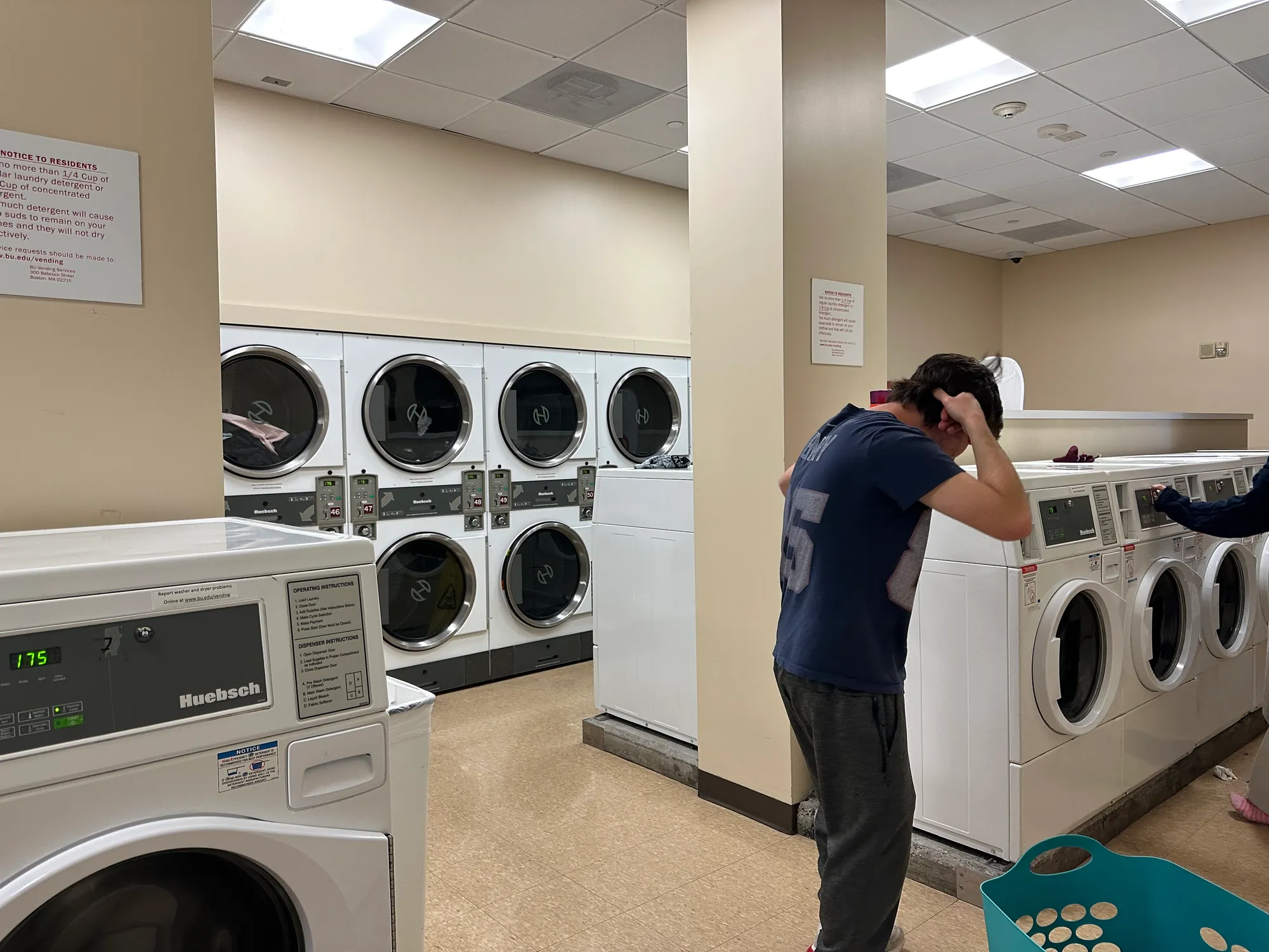 A cast member filming by the washing machines for Elevator Pitch